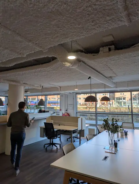 Open werkruimte met uitzicht op de sporen van Amersfoort Centraal, een van de werkplekken van gijsbodenstaff.nl
