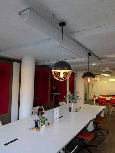 Werktafel en rode zitnissen in de lounge van het flexkantoor in Amersfoort, een van de werkplekken van gijsbodenstaff.nl