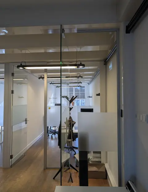 Glazen kantoorkamers op de tweede verdieping van Herengracht 280, een van de werkplekken van gijsbodenstaff.nl