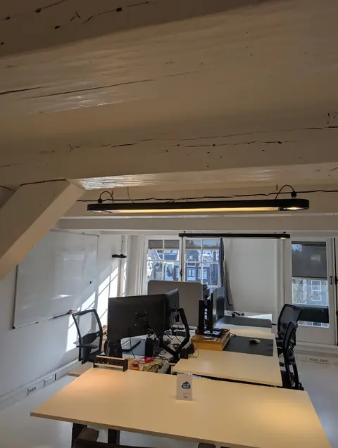 Werkplekken onder de balken op de zolder van Herengracht 280 in Amsterdam, een van de werkplekken van gijsbodenstaff.nl